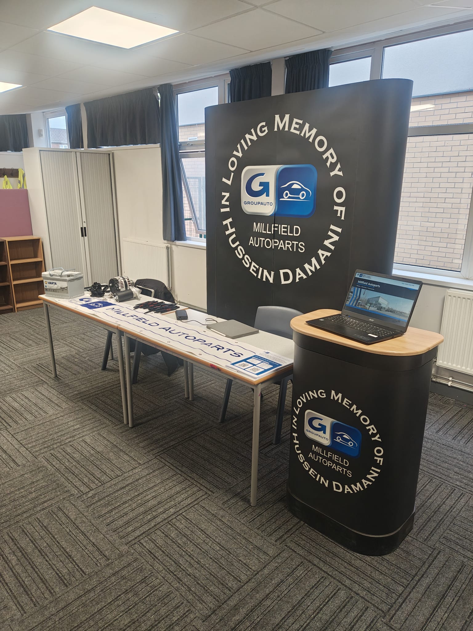 Millfield Auto Parts stand at City of Peterborough Academy Careers Fair with display banner and demo parts.